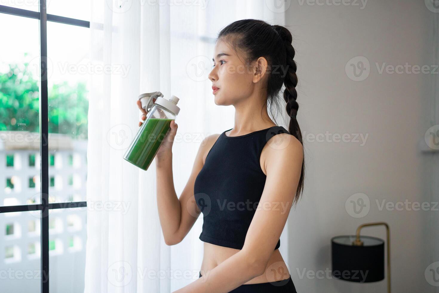 Fitness asian woman drinking organic green smoothie fruit detox for diet after workout exercise training in yoga studio healthy lifestyle photo