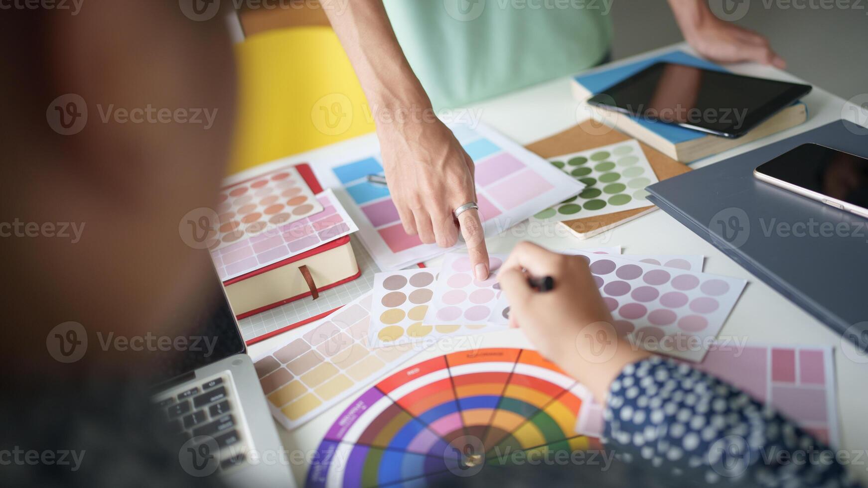 a person is working on a computer with a color wheel Teamwork brainstorming photo