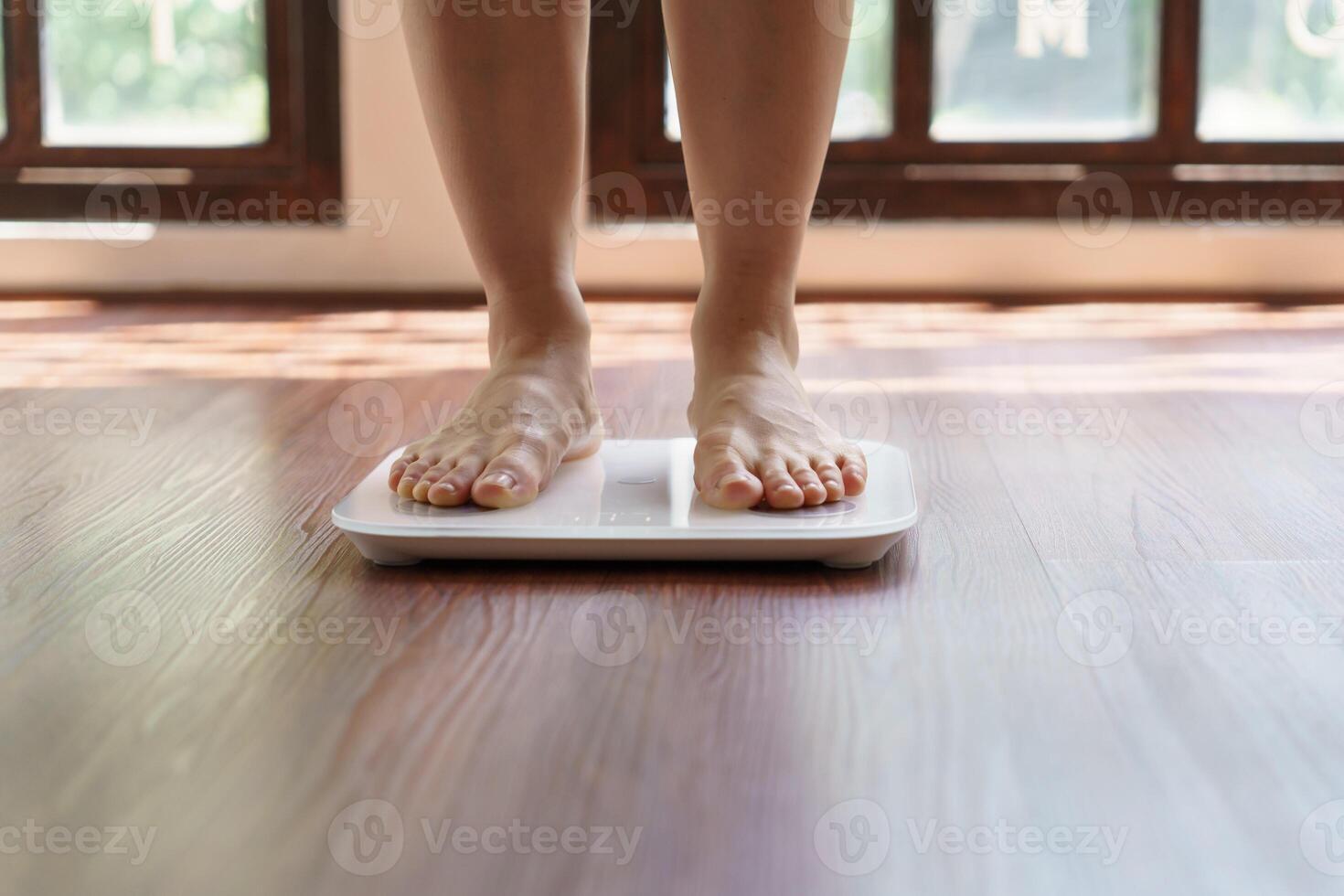 Fat diet and scale feet standing on electronic scales for weight control Measurement instrument in kilogram for a diet control. photo