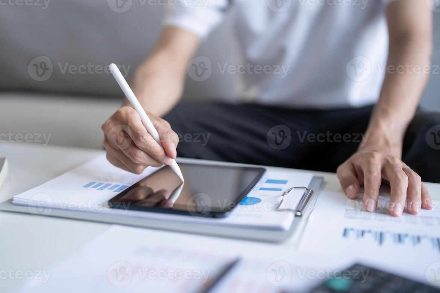 businessman using tablet and pen to write on paper. photo