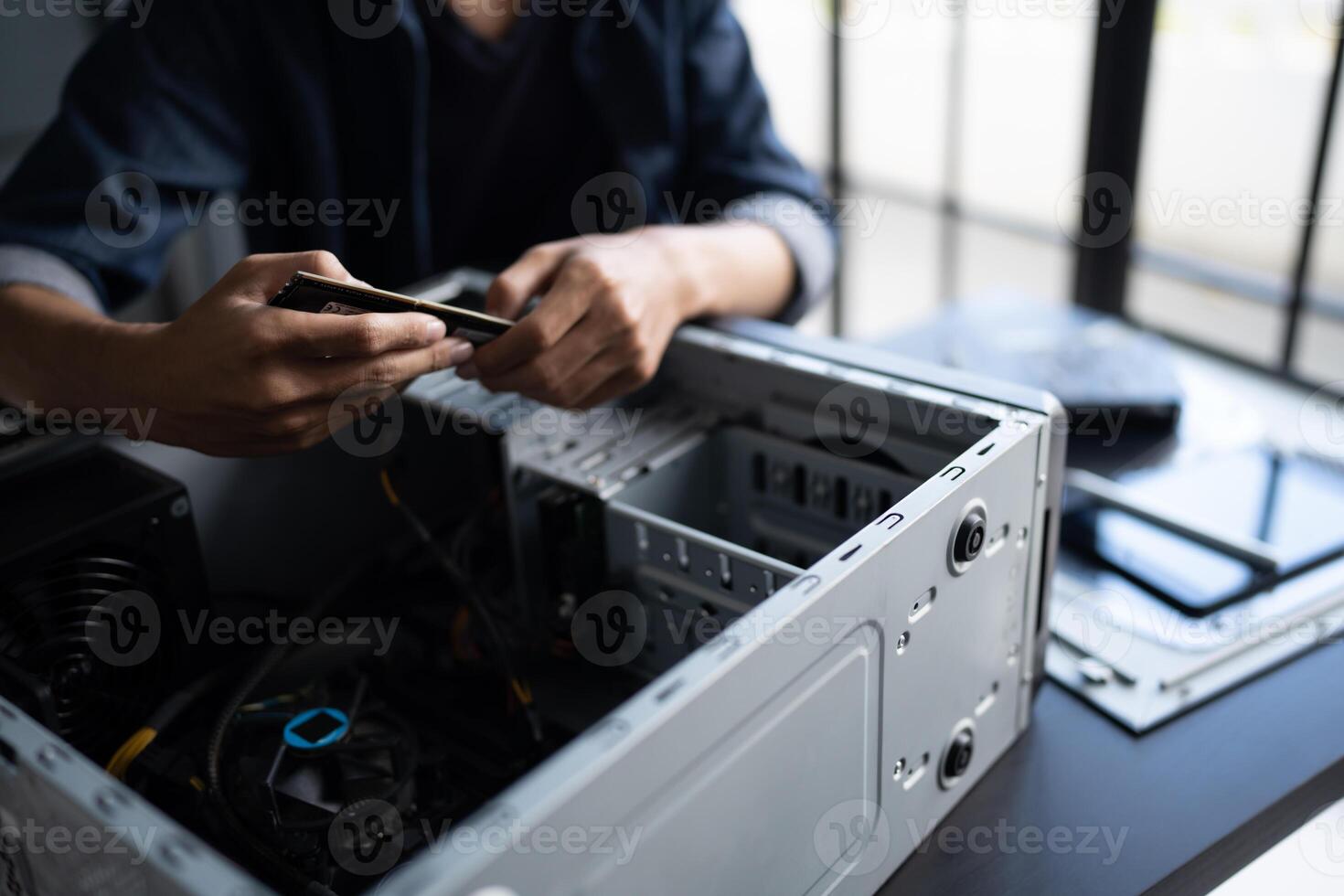 IT Engineer man is using a cell phone to check the status of his computer photo
