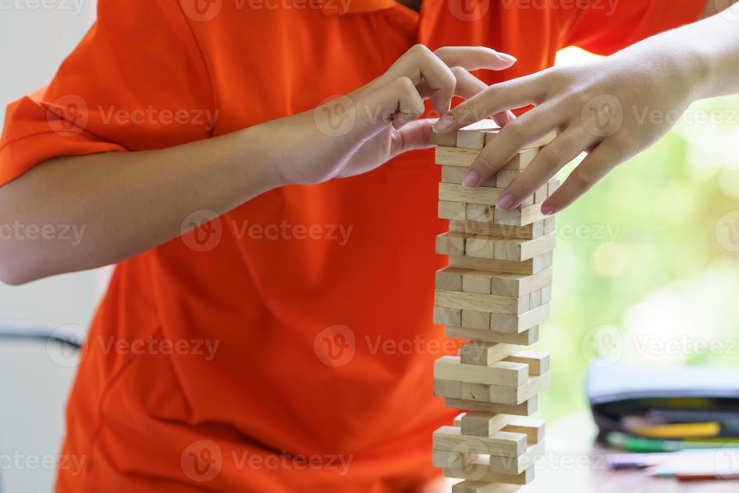 a person playing with wooden blocks on a table photo