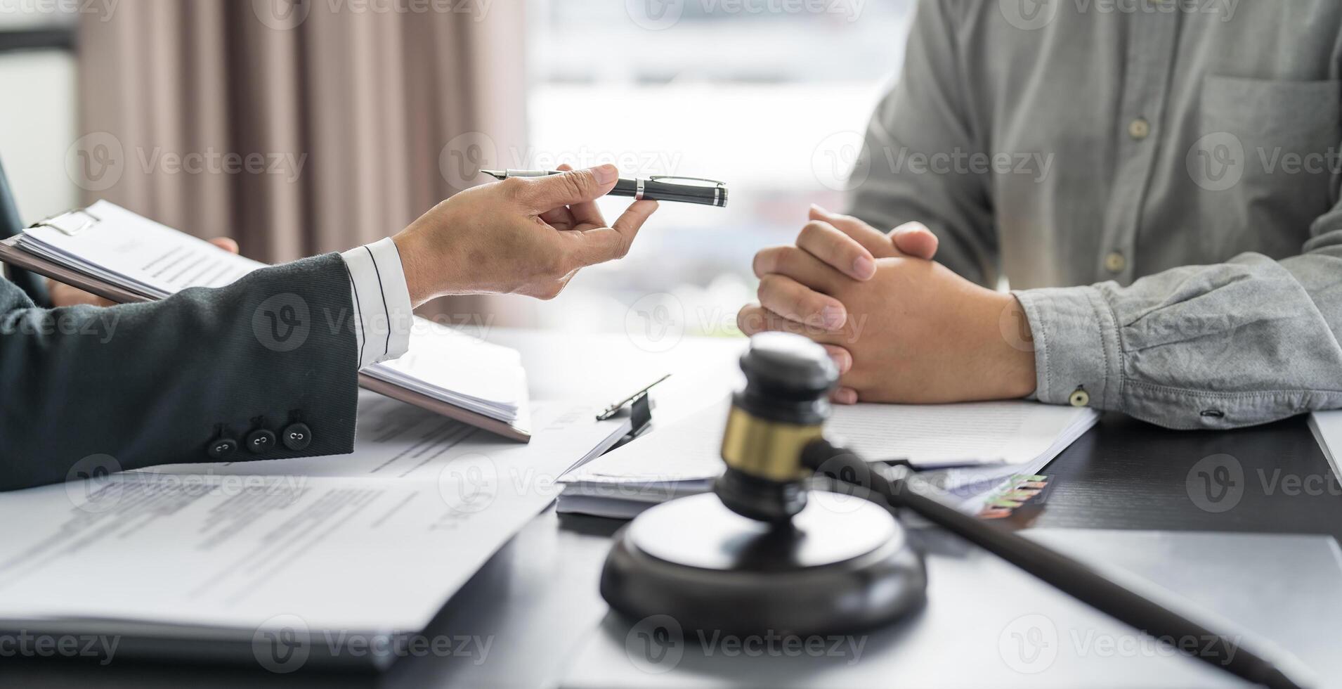 a judge holding a gavel and two people sitting at a table photo