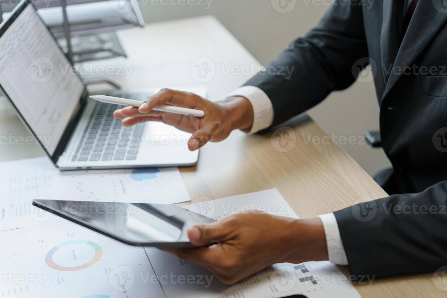 a man in a suit is using a tablet and pen photo