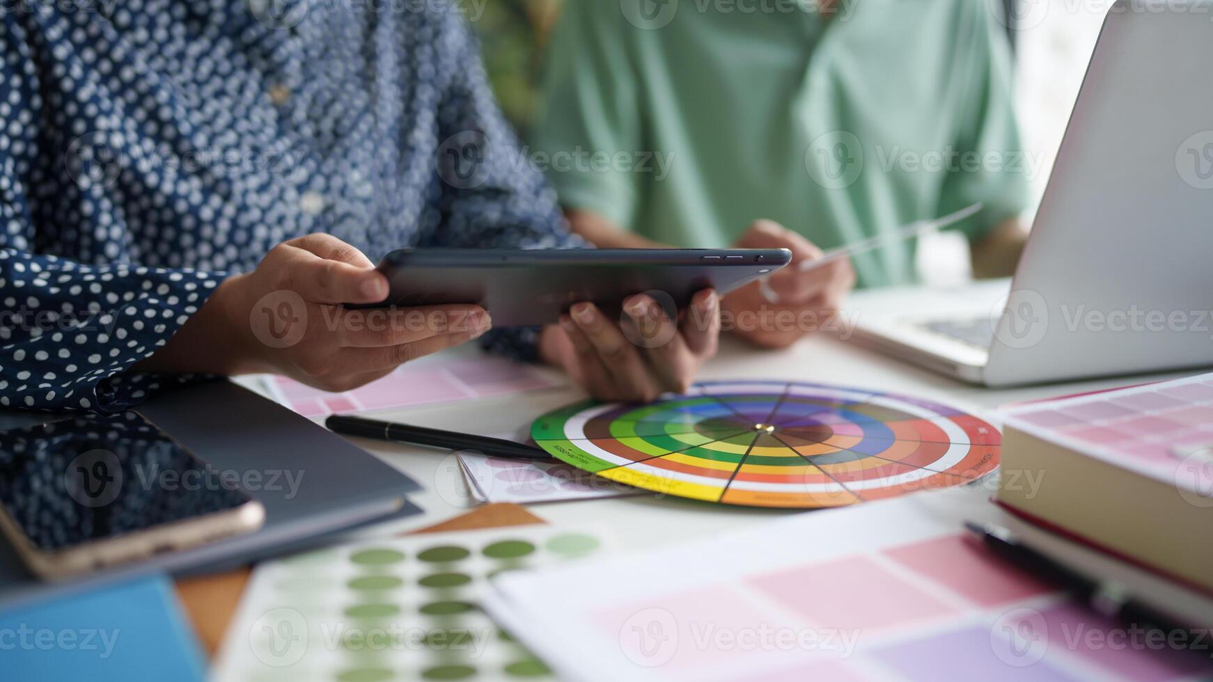 two creative is using a tablet and a color wheel photo