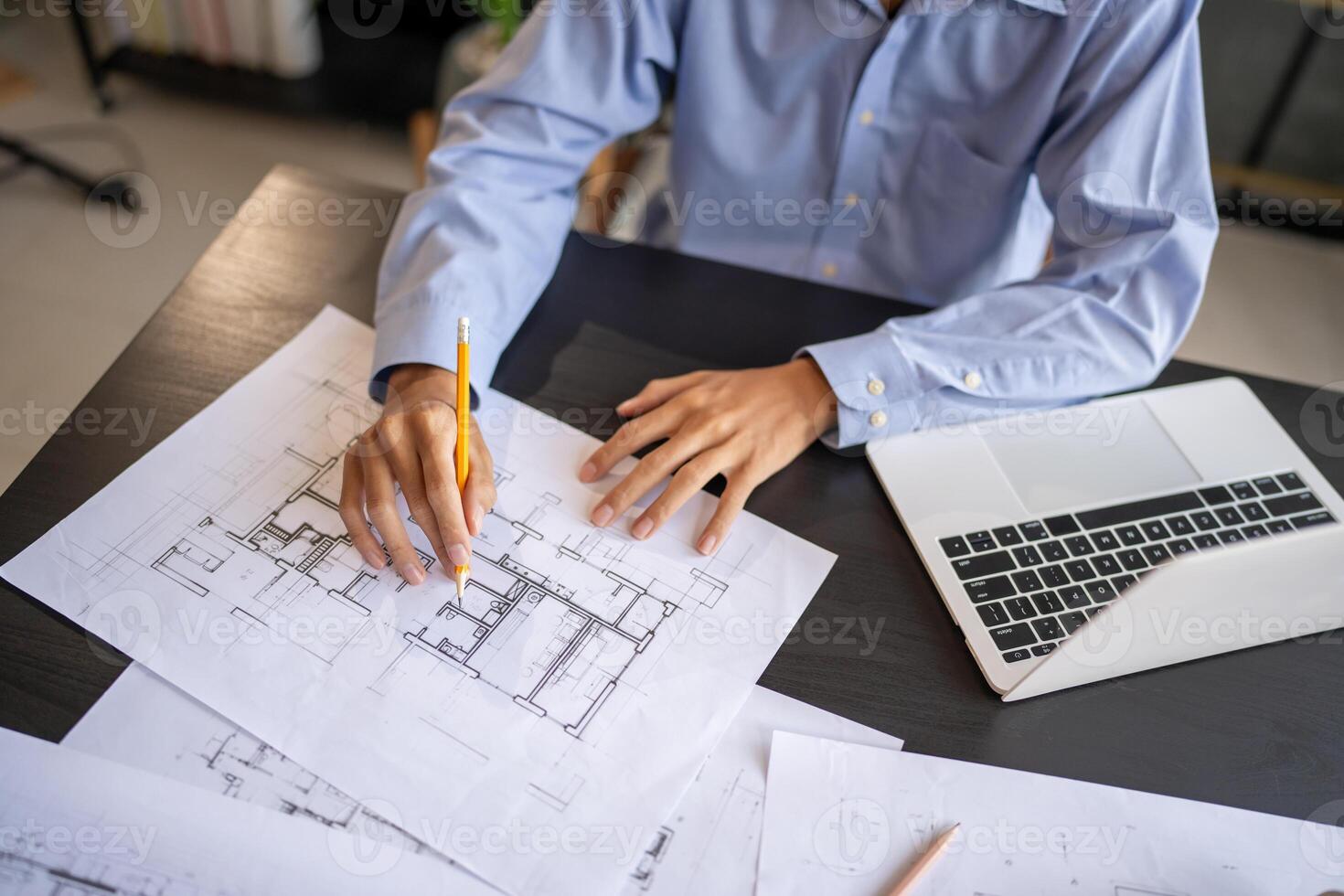 Architecture Man man is working on blueprints with a pencil photo