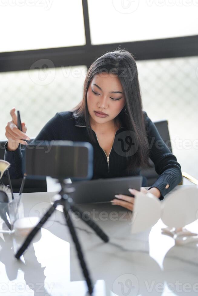 a woman sitting at a table with a tablet and a camera photo