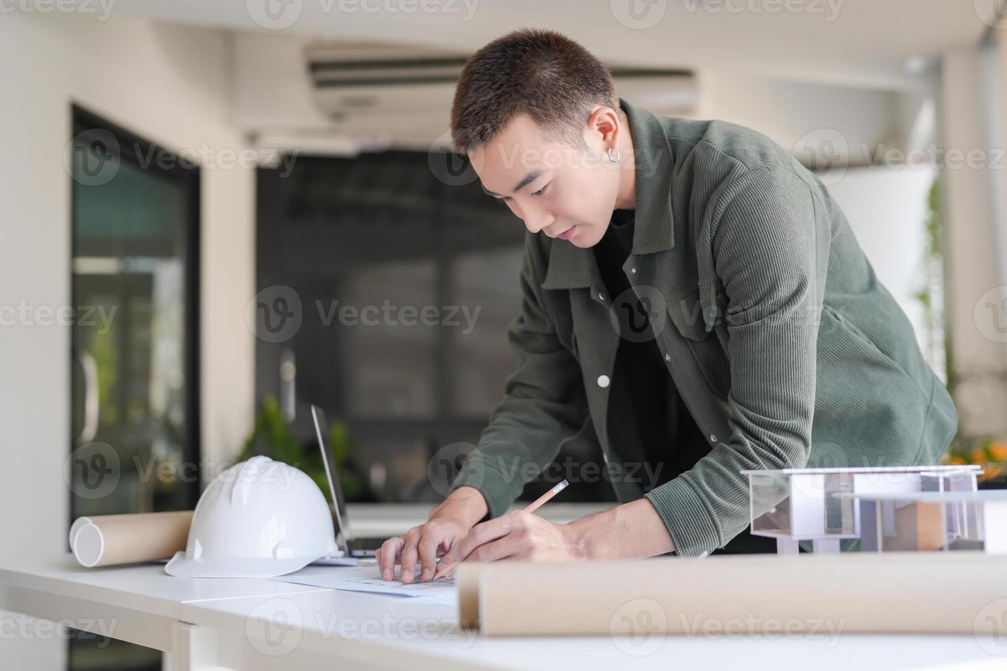 Architecture man in a green jacket writing on paper photo