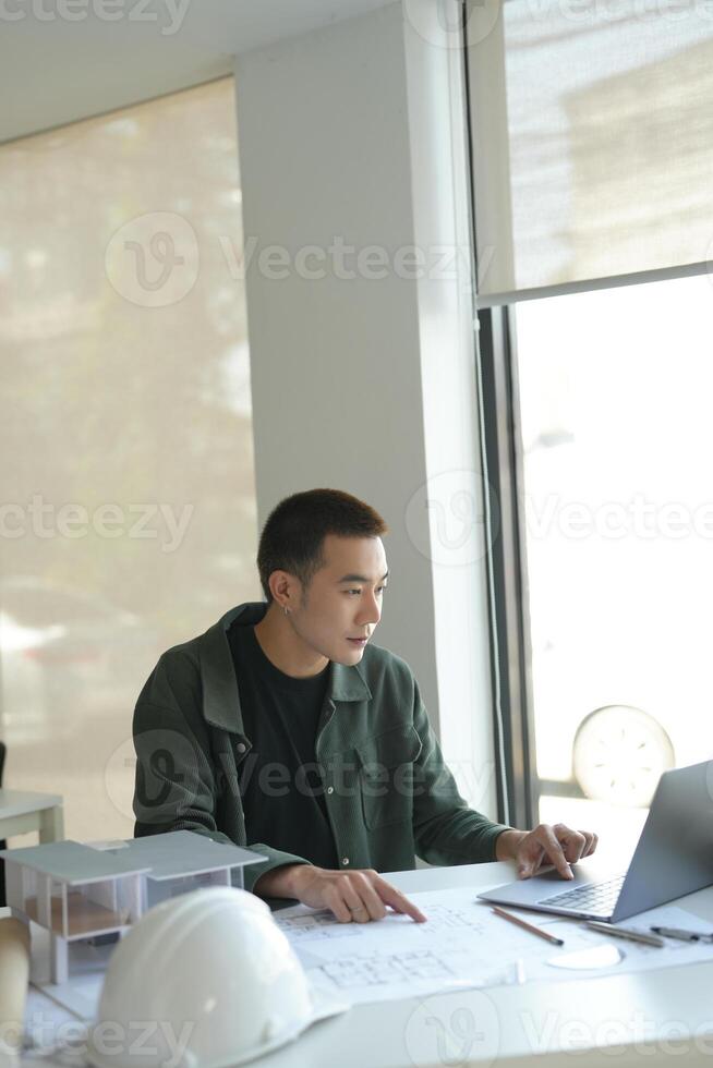Architecture man sitting at a desk with a laptop photo