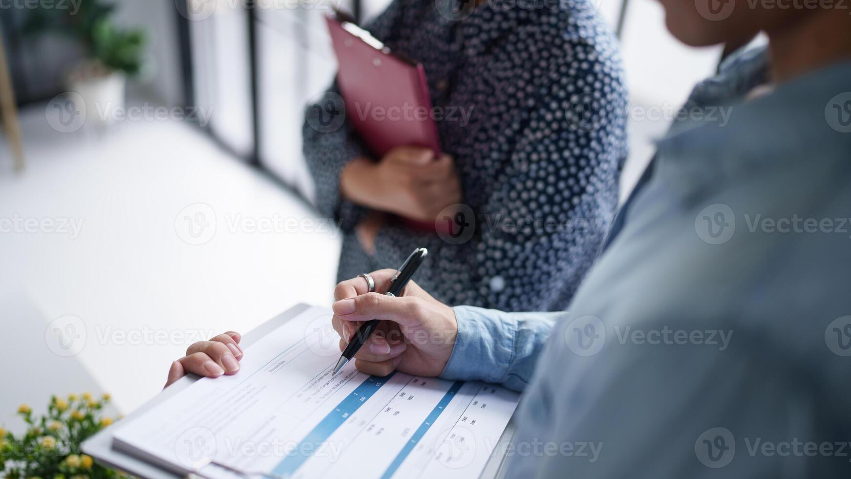 Teamwork brainstorming man and woman are holding a clipboard and writing on it photo