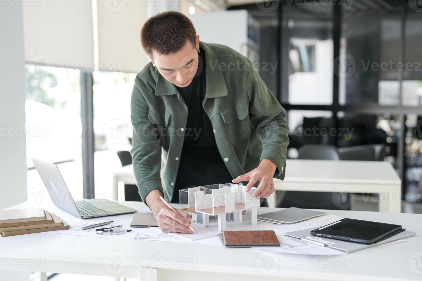 Architecture is working on a model of a house at office photo