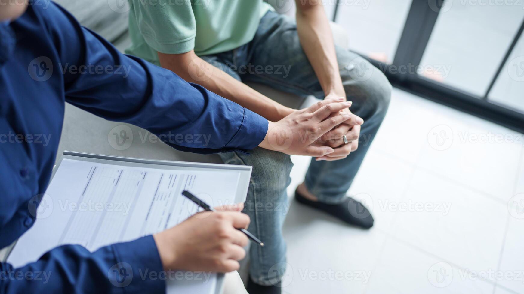 Professional psychotherapy sitting on a couch with his hands on his lap photo