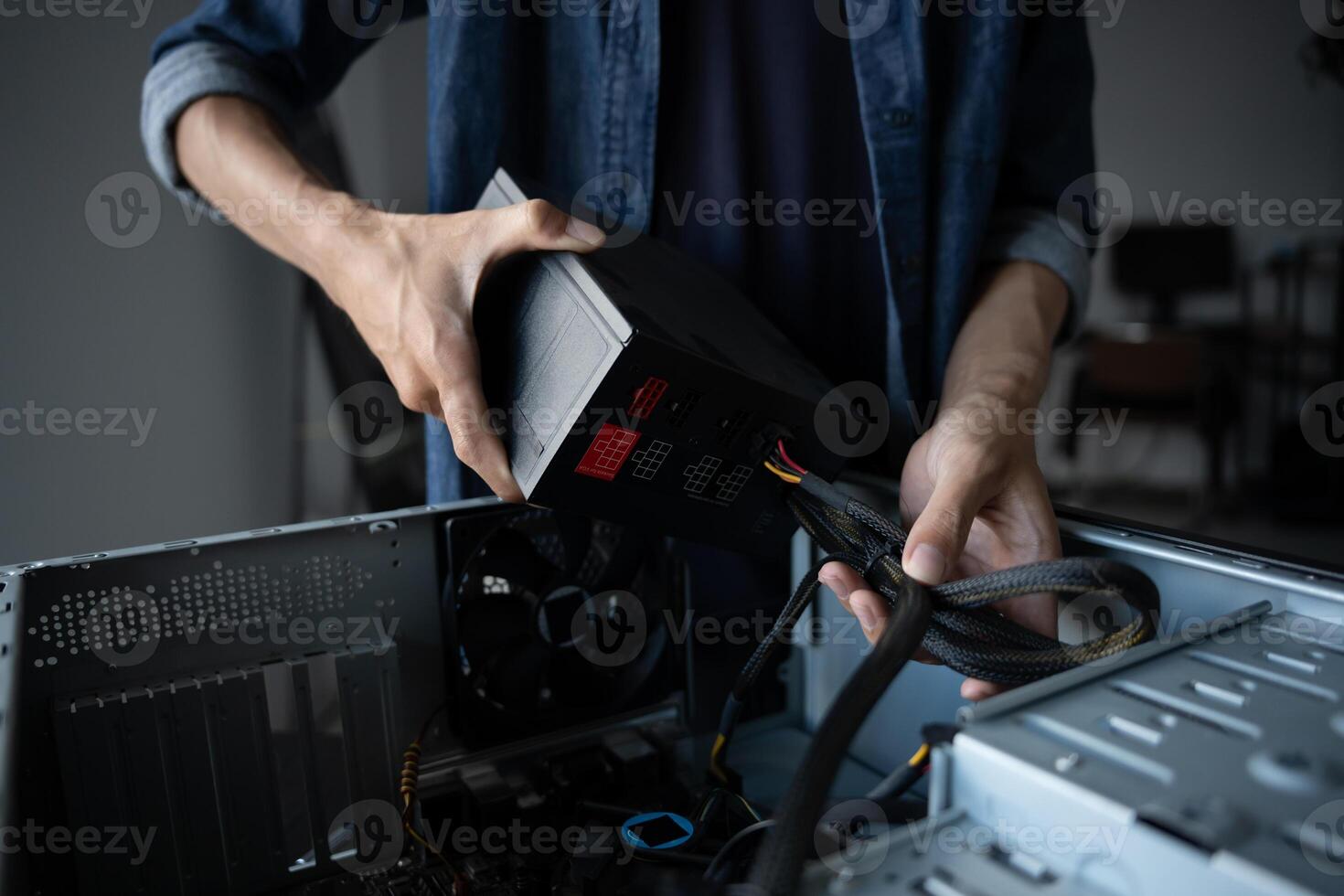 IT Engineer man is holding a computer and plugging it into a power supply photo