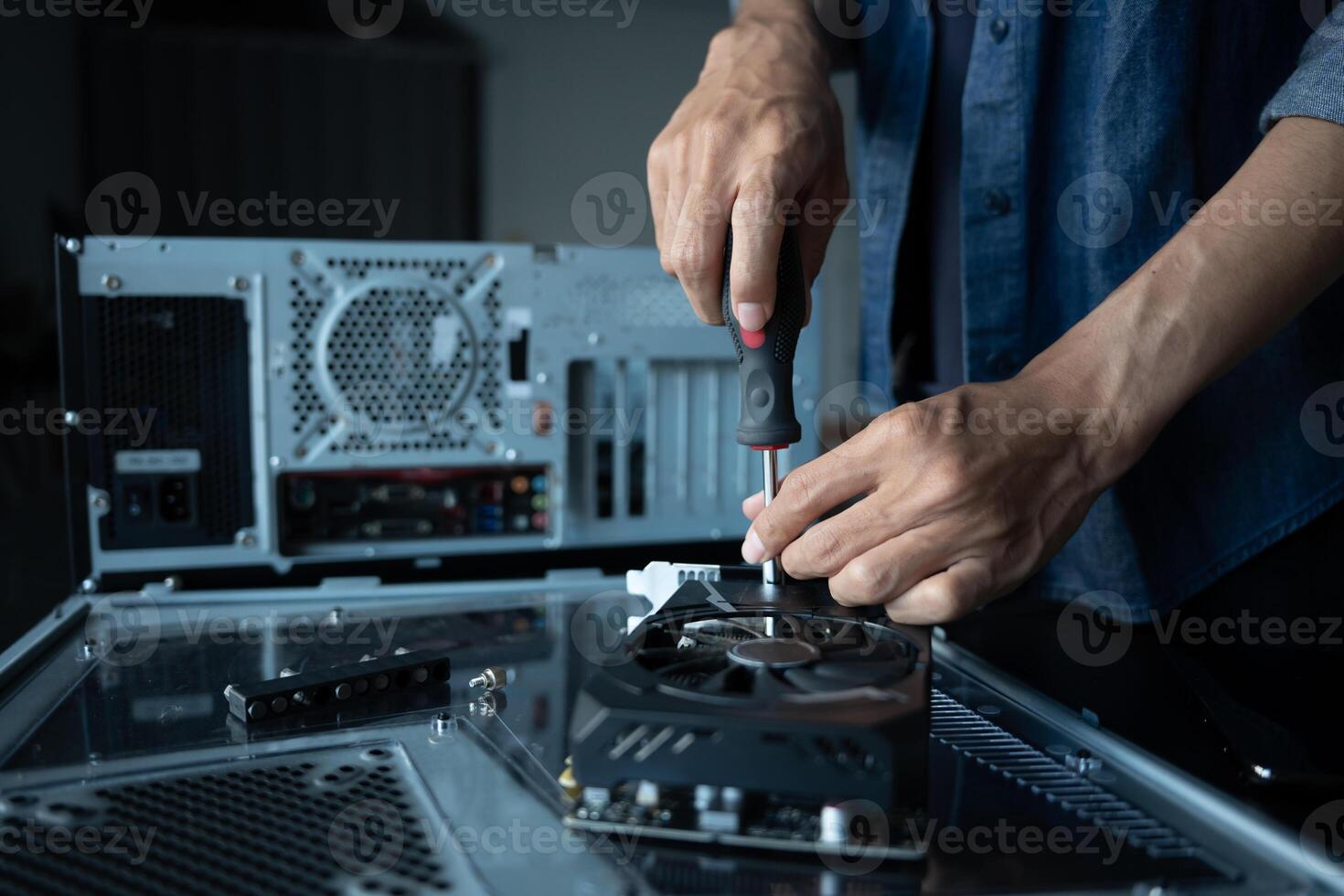 engineer is fixing a computer with a screwdriver photo