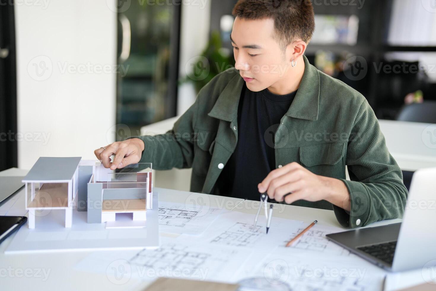 Architecture Man is working on a model of a house in office photo