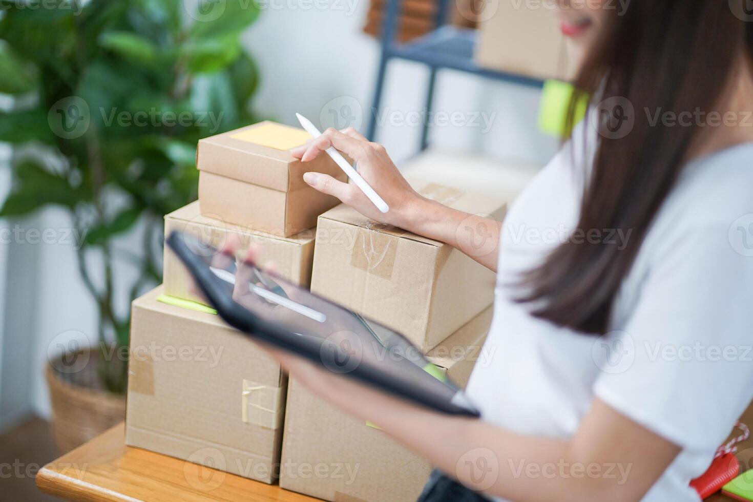 Business From Home Asian woman preparing package delivery box Shipping for shopping online. young start up small business owner at home. photo