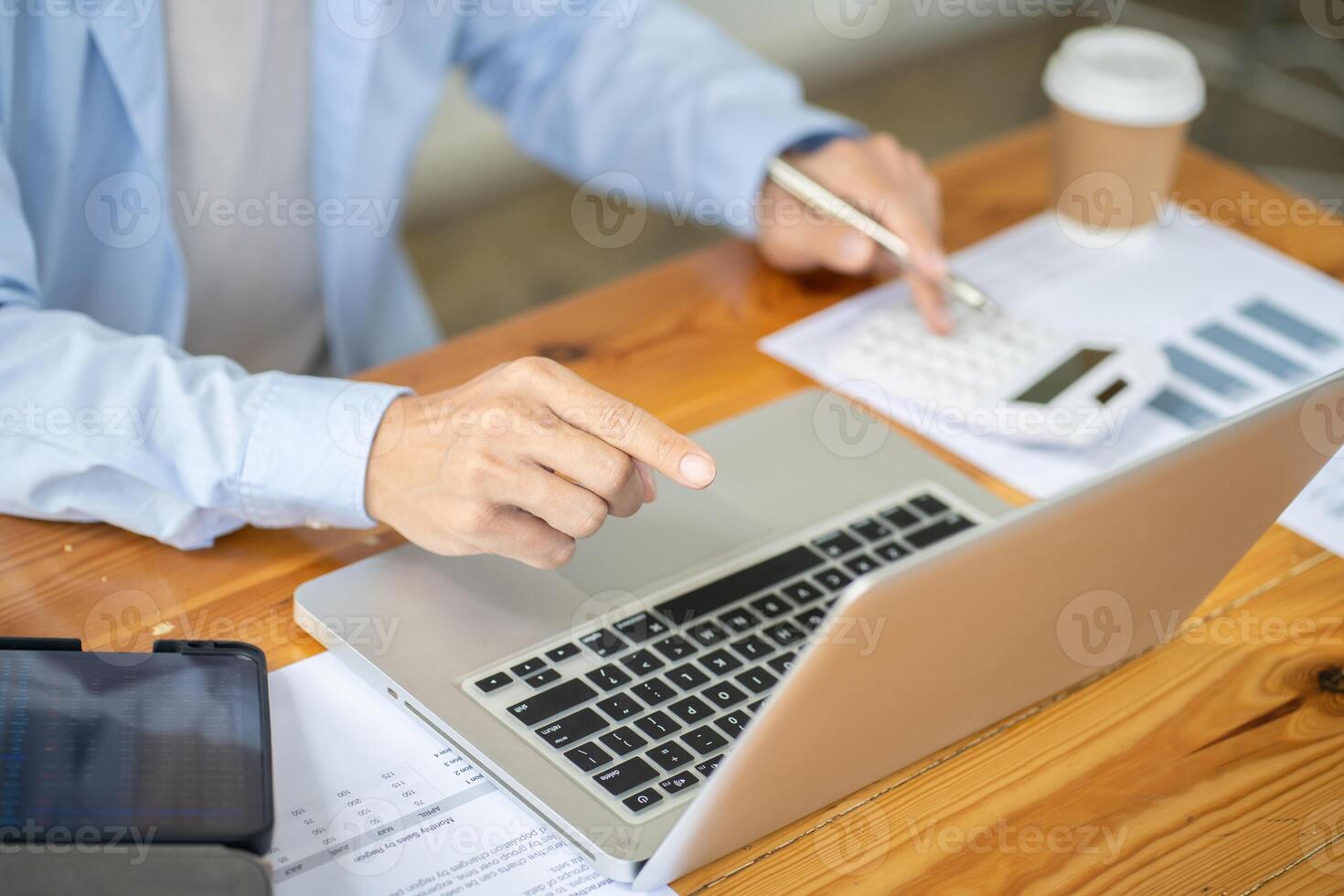 a man is using a laptop computer with a calculator. photo