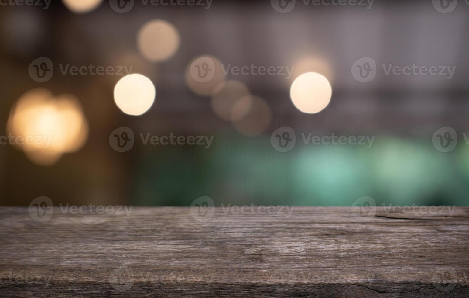 a wooden table with blurred lights in the background photo