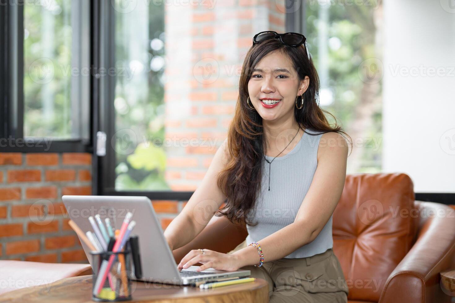 Portrait of Asian business female using laptop beautiful woman working on a computer in stylish Working Design in workplace. photo