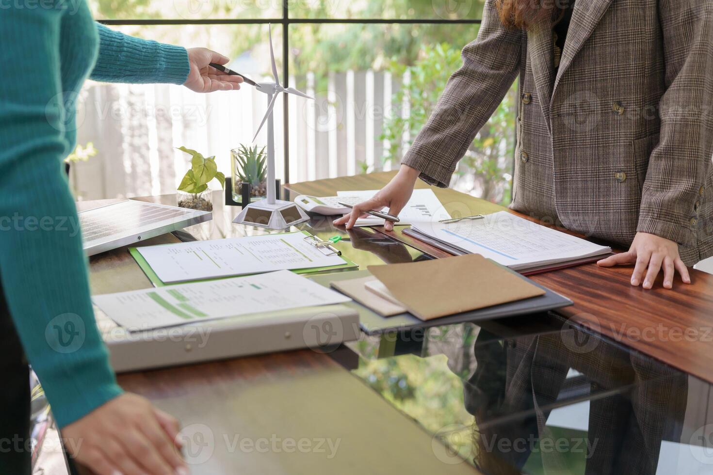 two business people standing at a desk with papers and a laptop photo