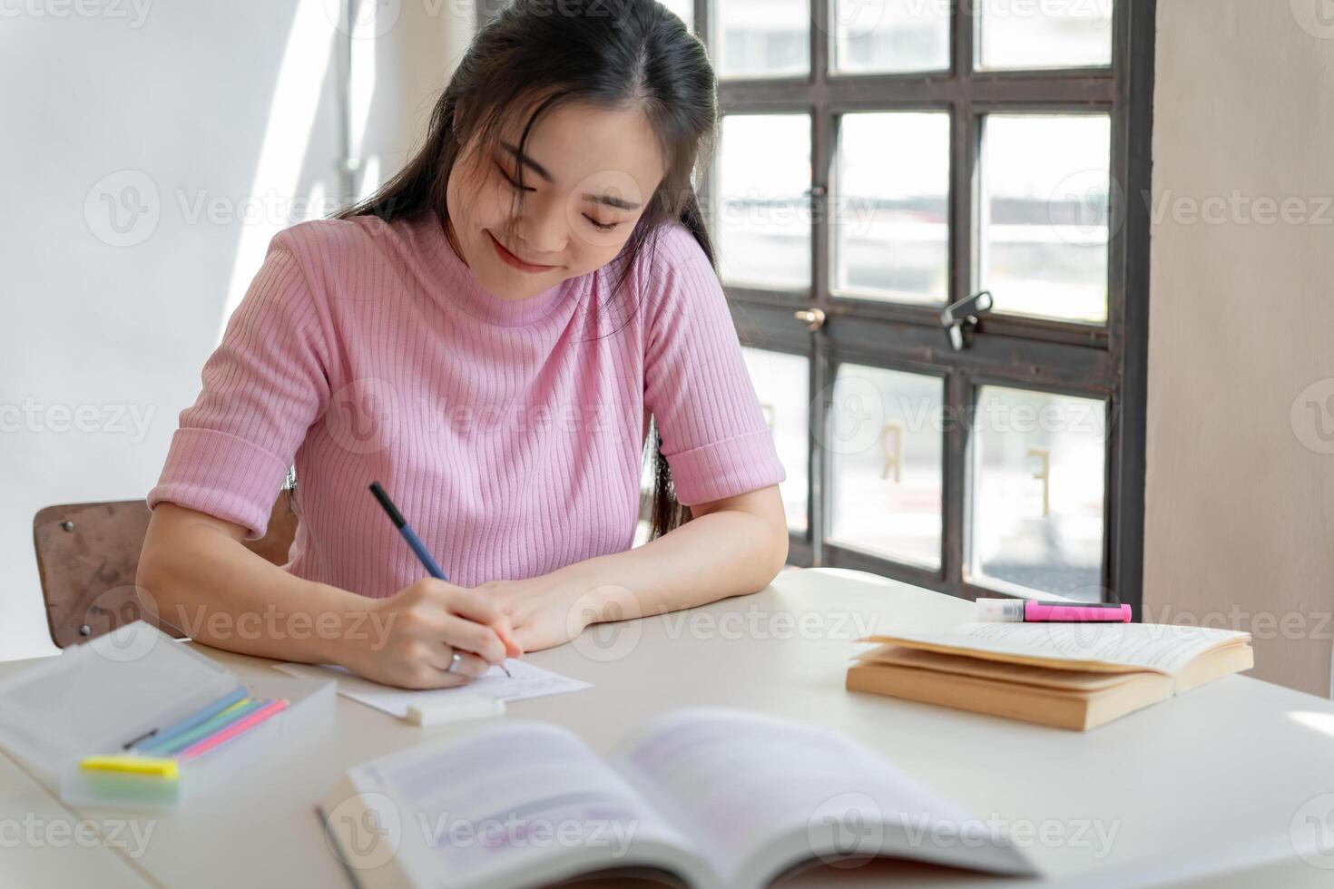 Asian girl student doing exam. hand holding pencil writing answer in university classroom education high school or university student taking notes while preparing for exam photo