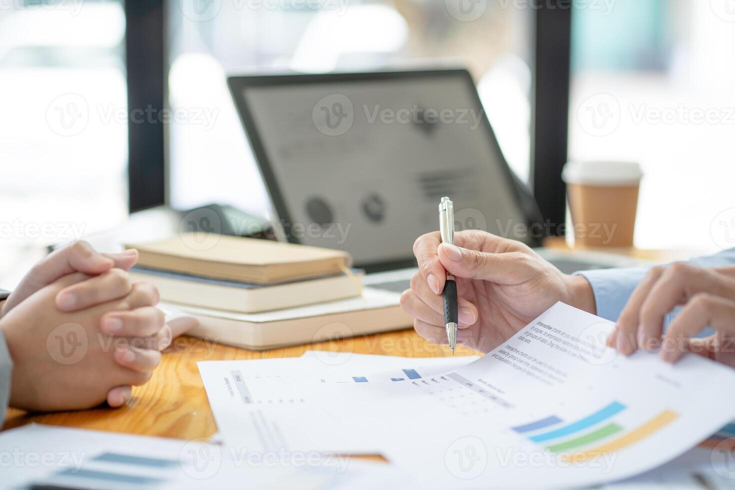 two business people sitting at a table with papers and pens in meeting room photo
