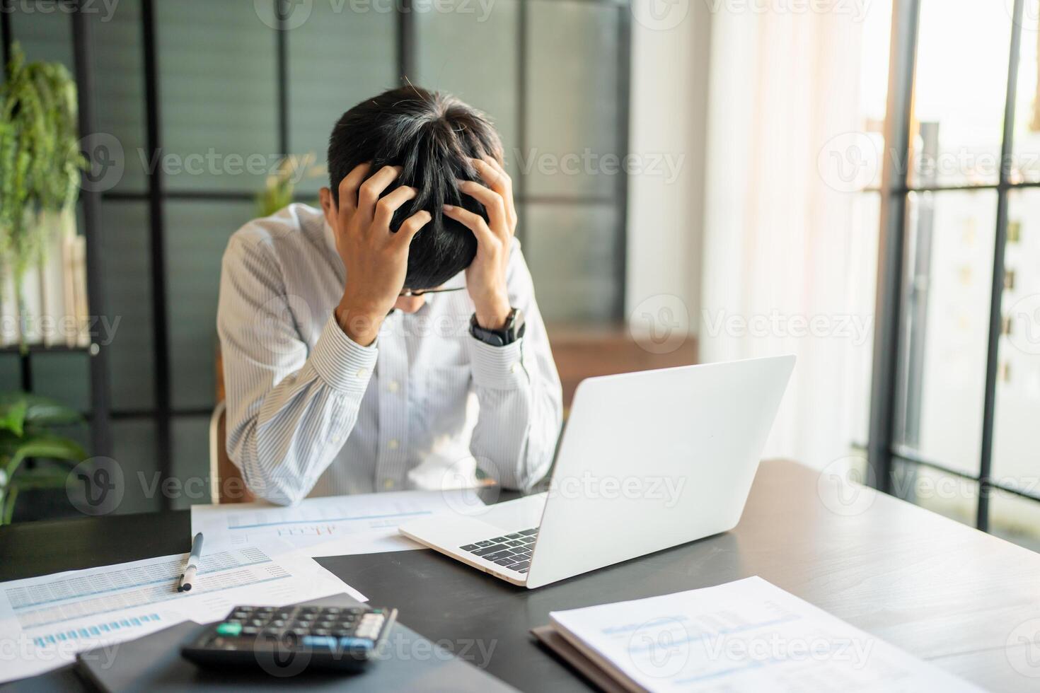 Asian Business man tiredness and stress while having headache. Painful men are stressed at work in office. photo