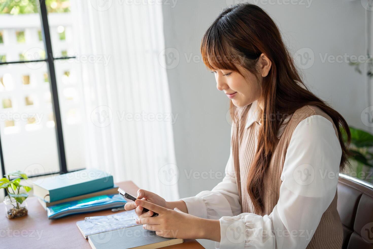 Student asian woman lying use smart phone in dorm room college mobile addict spending time checking news technology photo