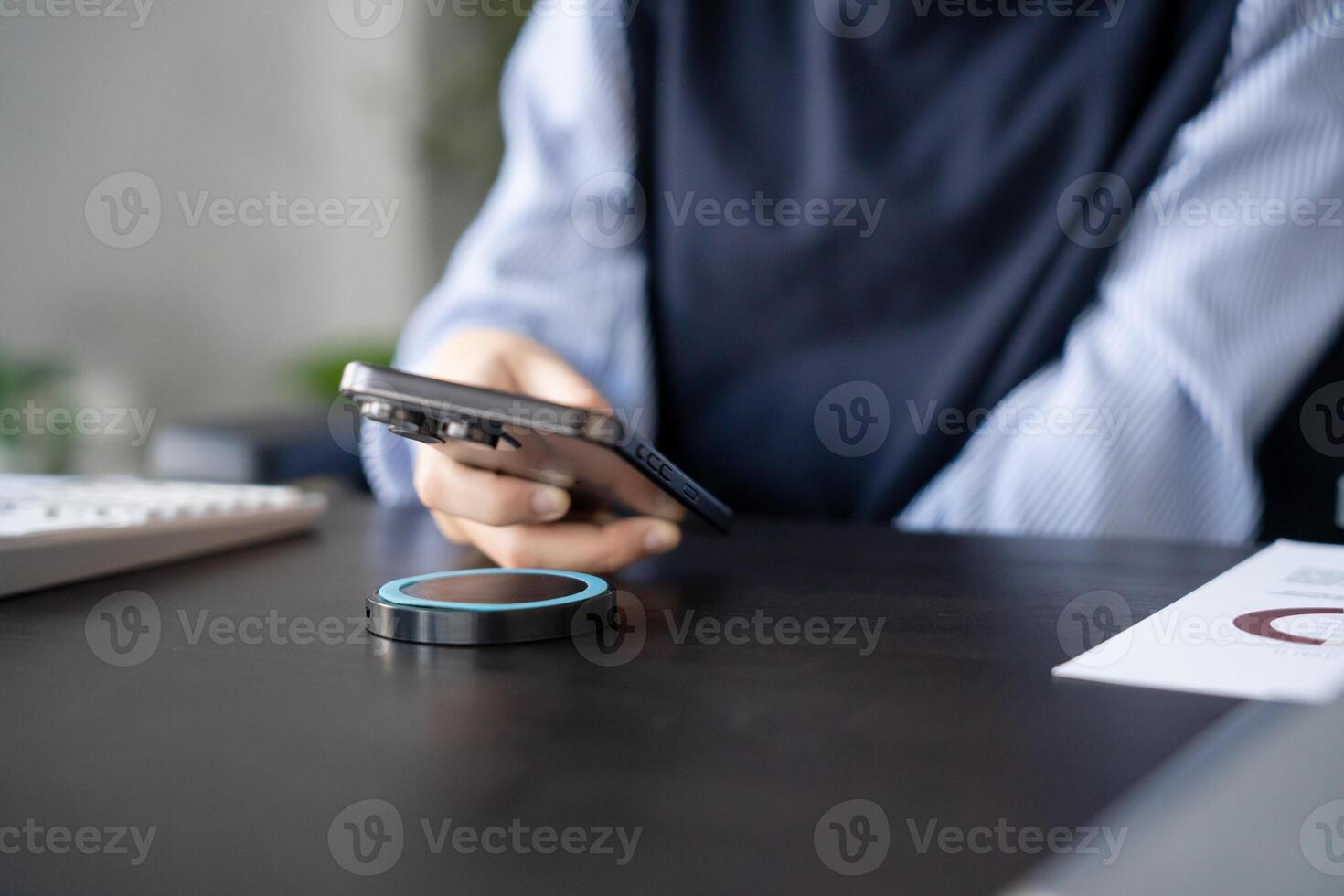 a person using wireless charging with smart phone photo