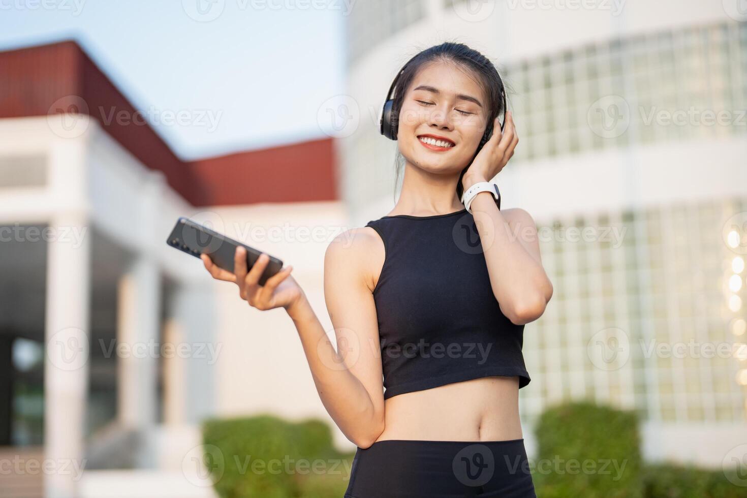 asian woman listening to music with headphones outdoors. photo