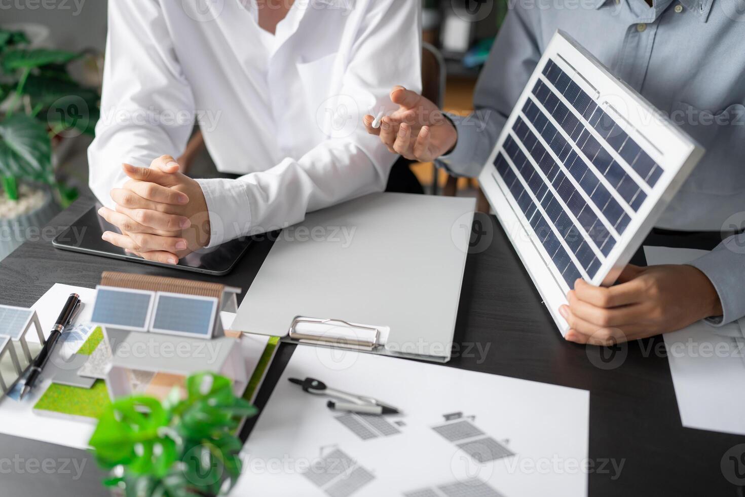 two engineers sitting at a table with a solar panel. photo