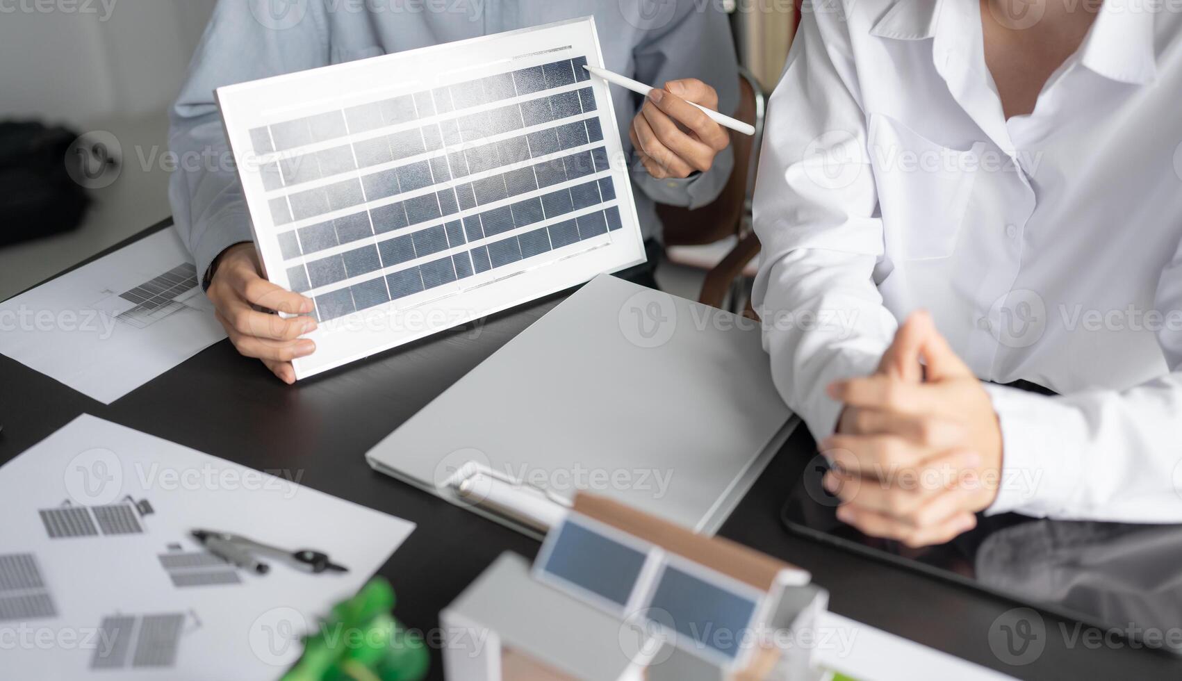 two people are holding up a solar panel photo