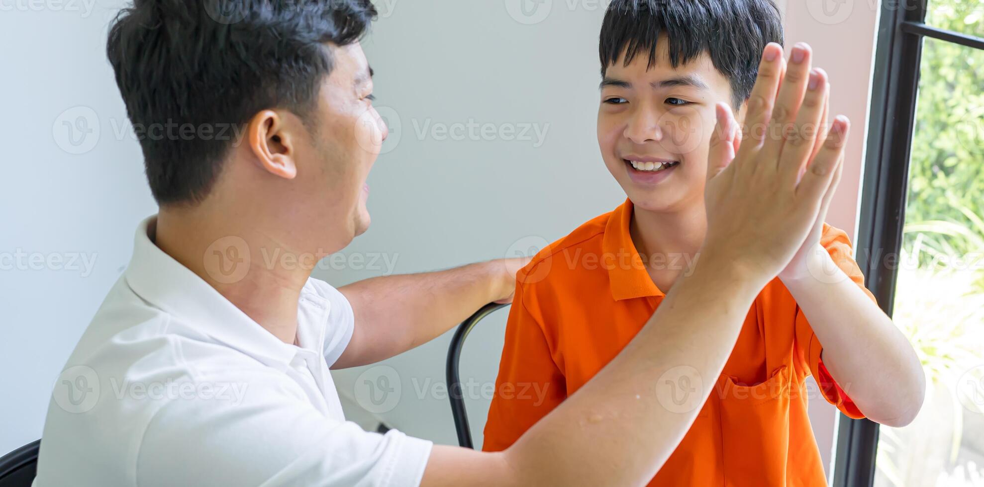 a man and boy are giving each other high fives photo
