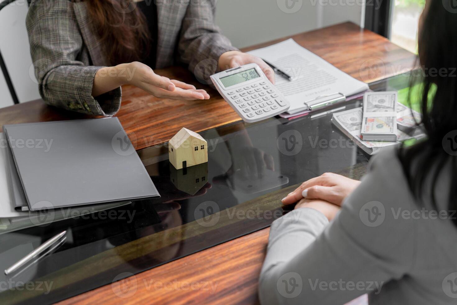 two business women sitting at a table with a calculator and papers. photo