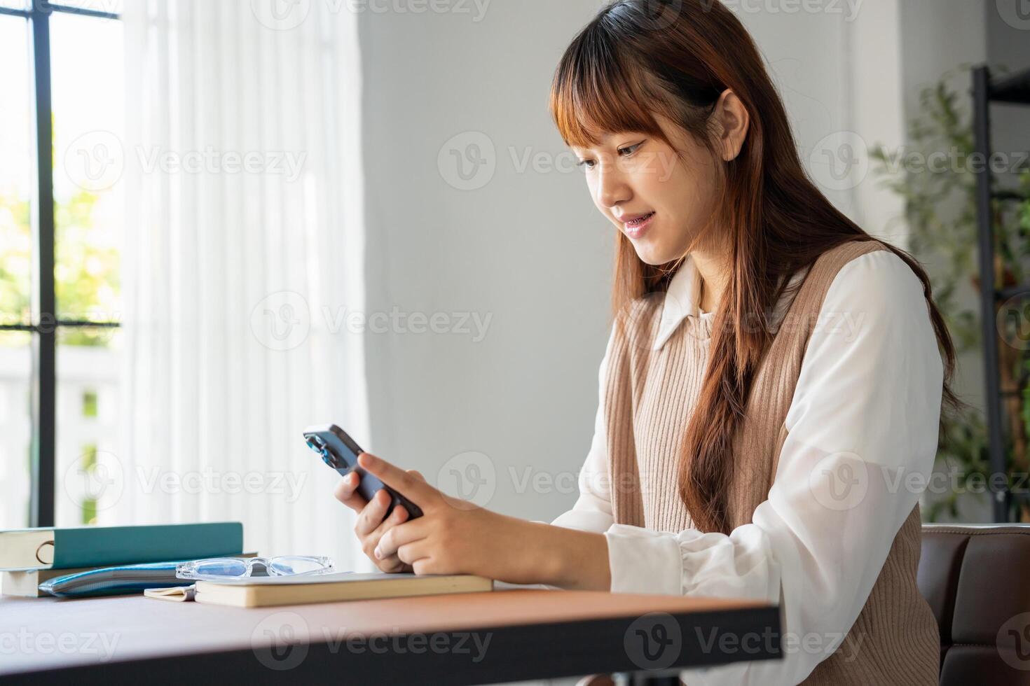 Student asian woman lying use smart phone in dorm room college mobile addict spending time checking news technology. photo