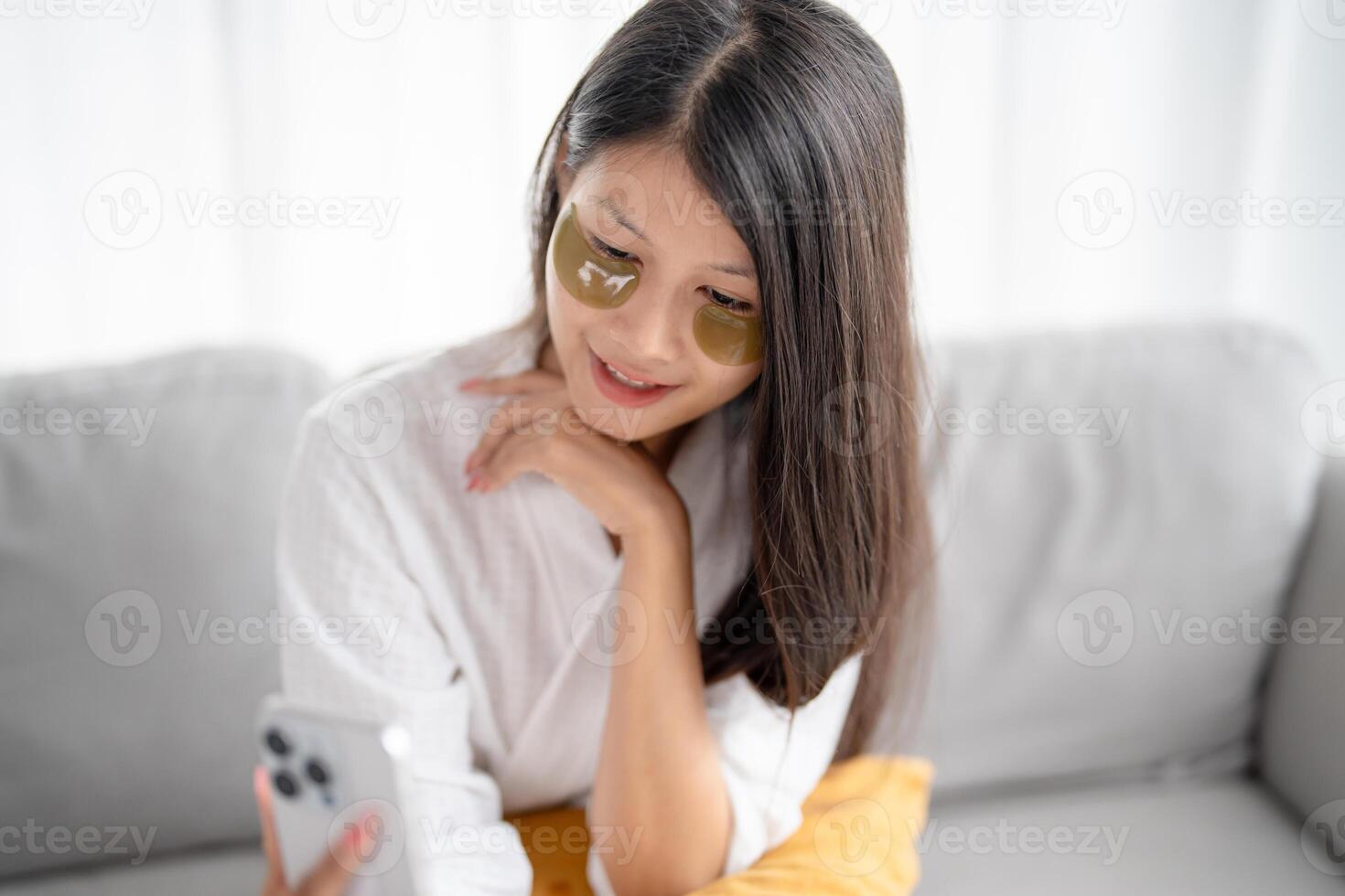 Asian woman applying self care and relax with silicone under eye patches smiling happy using skincare product photo