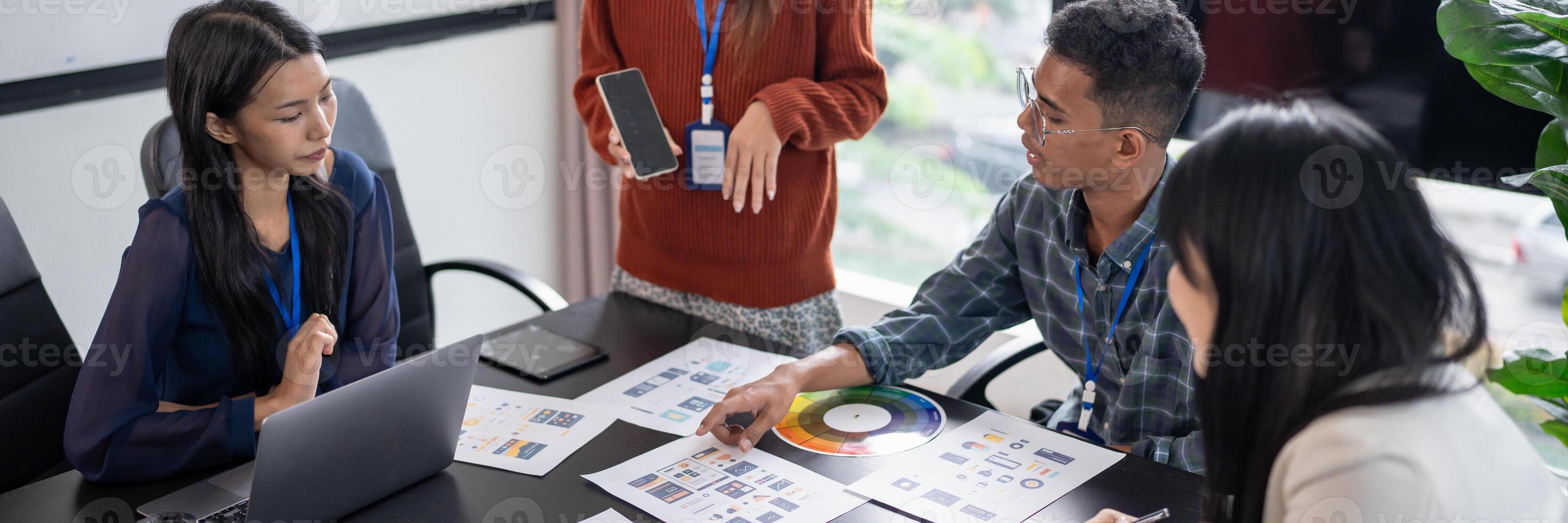 Asian business people Application Designers presenting trending products report mobile application planning process development software design project ux Graphic designer. photo