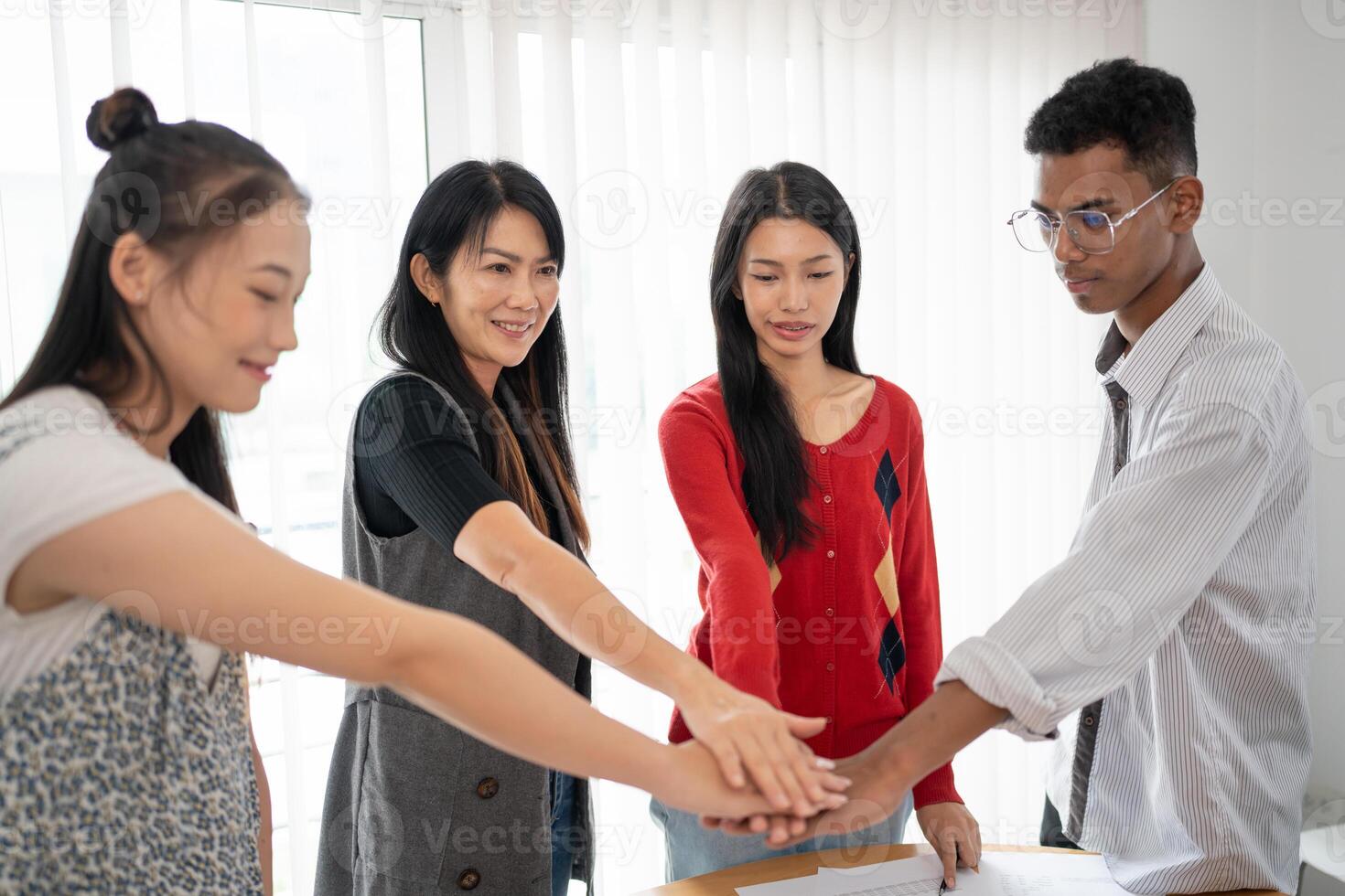 Team building of people Asian business hands stack unity and support Team fold their hands on each other. photo