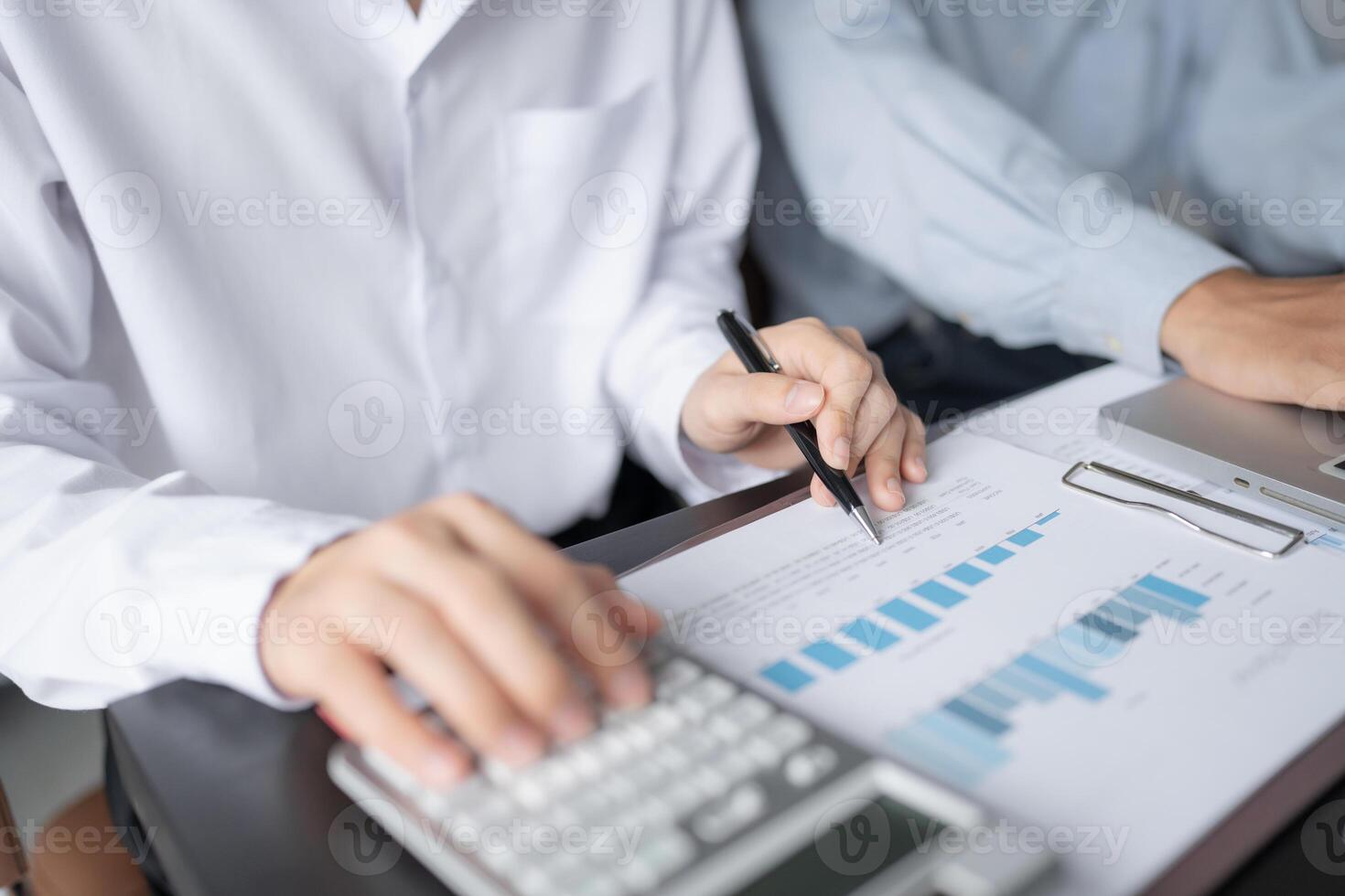 two people are working on a laptop and a calculator photo