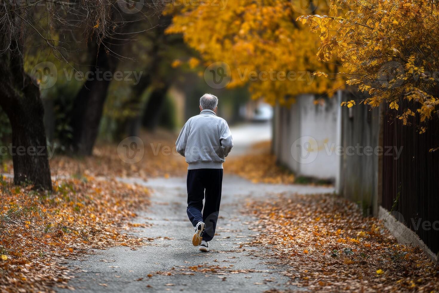 An older man is running down a path in the fall photo