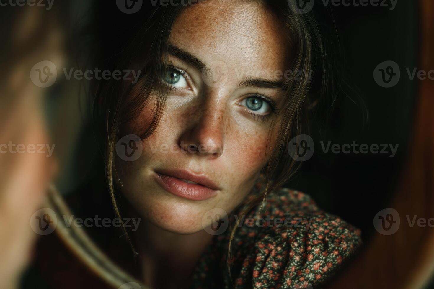 A woman looking into a mirror with freckles photo