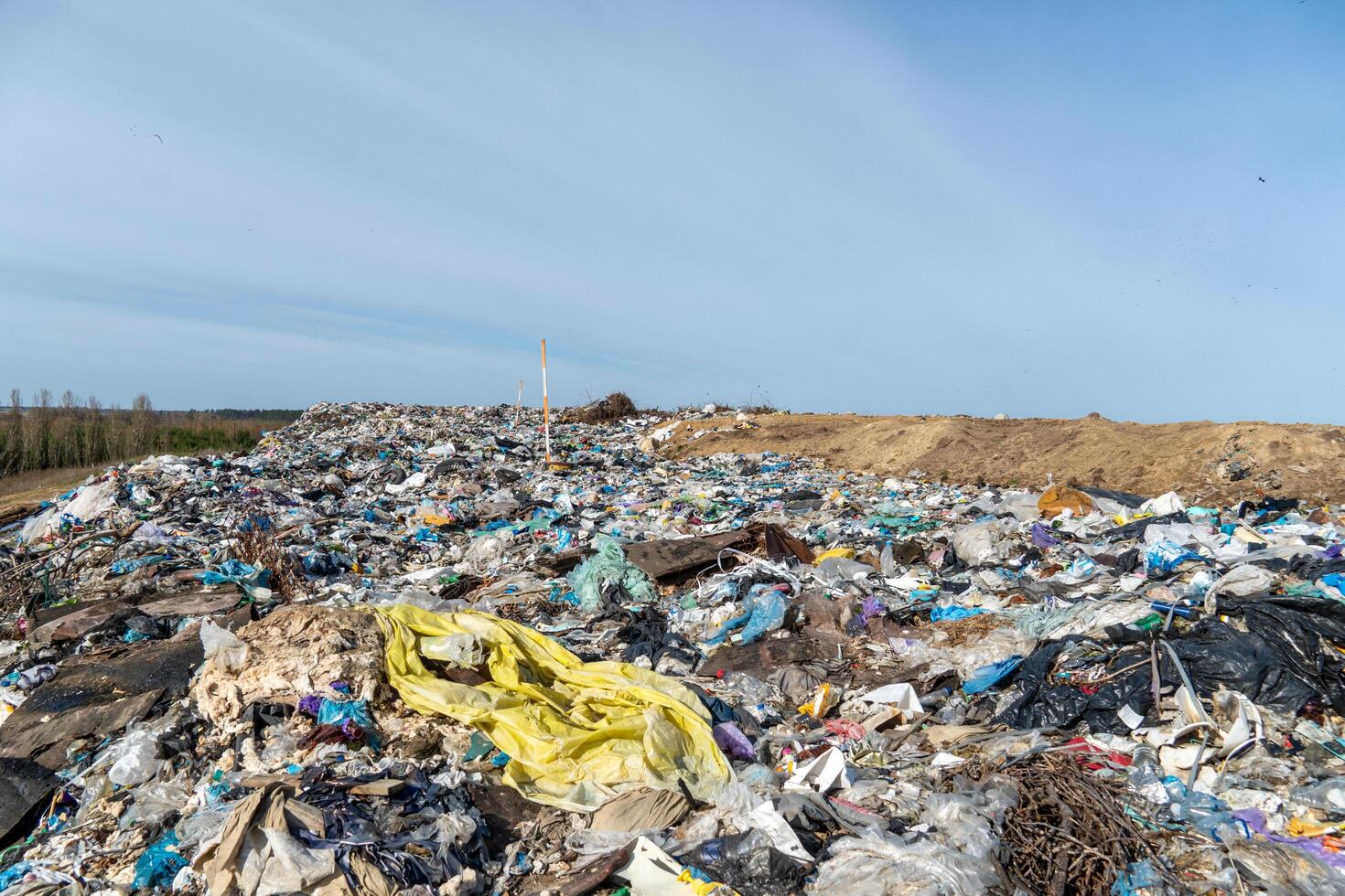Waste Accumulation Site Shows Piles of Trash Under Blue Sky, Demonstrating Environmental Concerns with Landfill Management photo