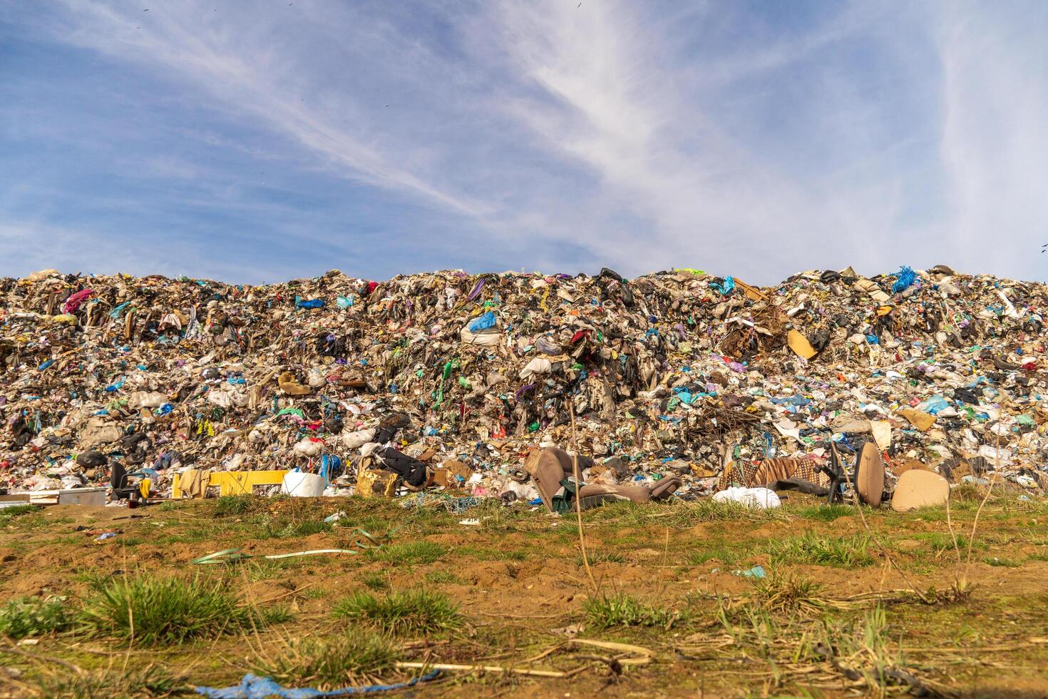 Massive Landfill Accumulation Overflows in an Environmental Disaster Scene Under a partly Cloudy Sky photo