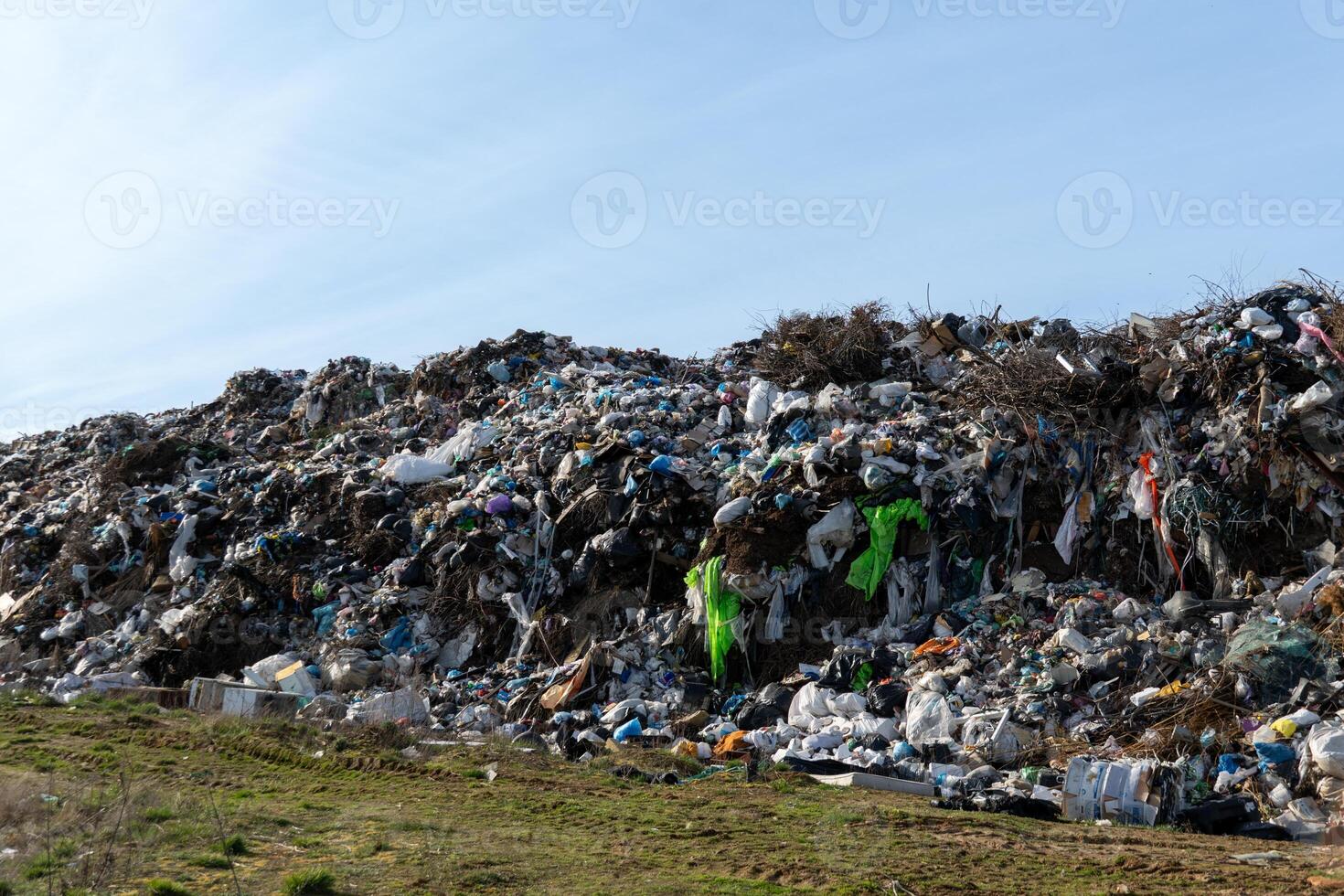 Massive landfill filled with mixed trash and waste material creates environmental challenge and pollution concern on sloping ground photo