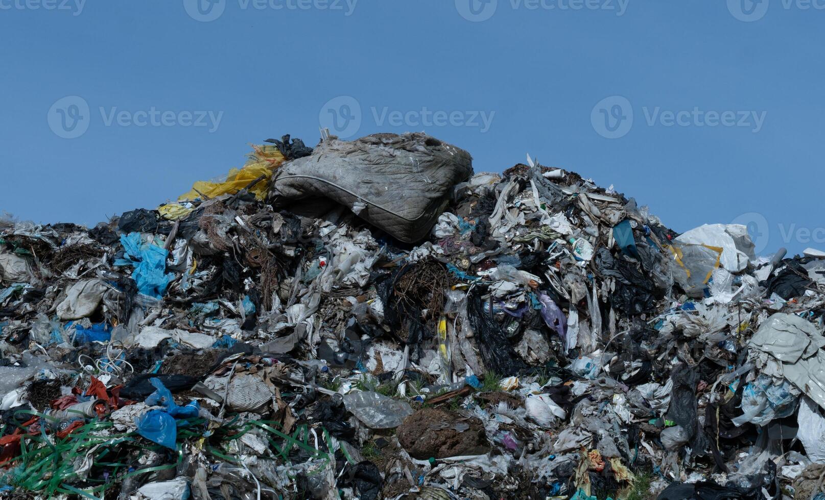 Large Pile of Mixed Waste and Refuse Against a Clear Sky photo