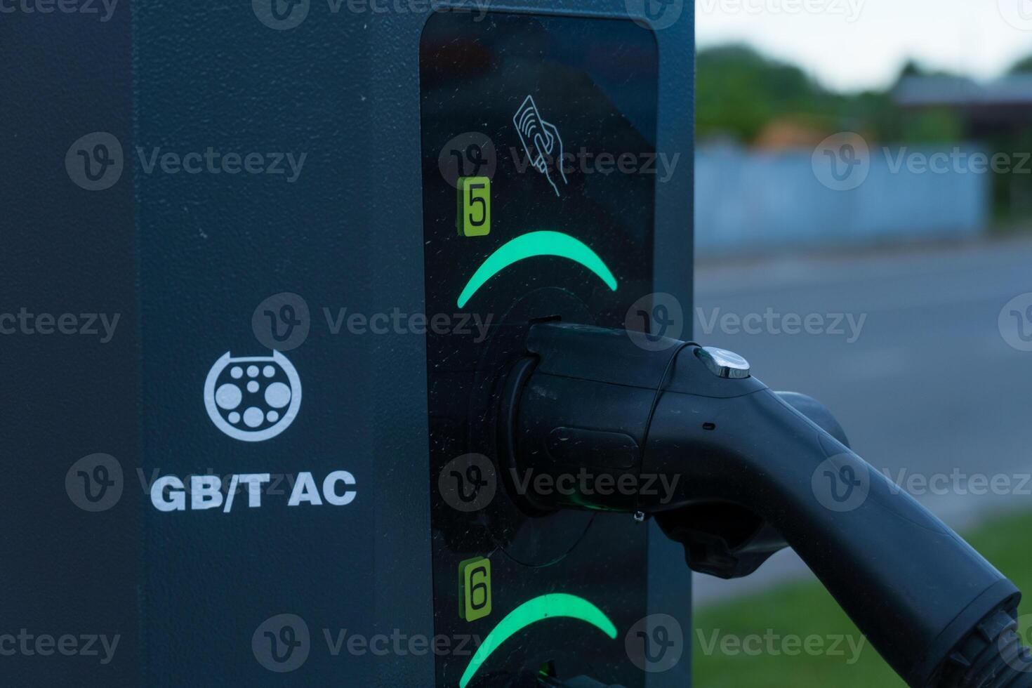 Electrical Automobile Charging Station with Plug Connected at Nighttime photo