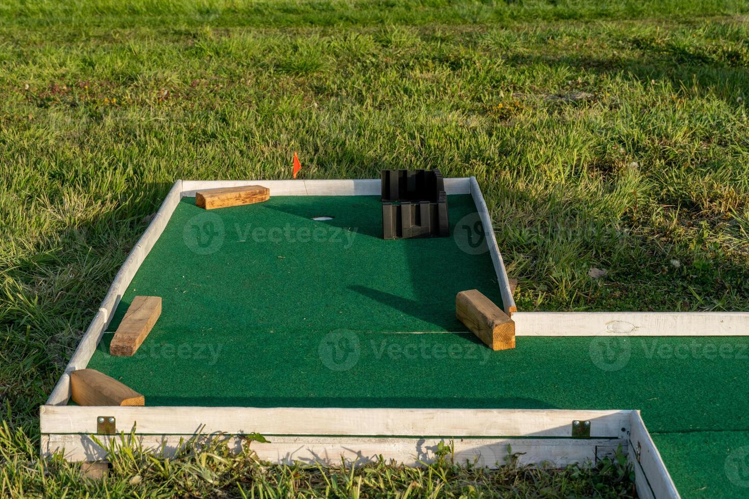 Miniature Golf Course Hole with Obstacles on Green Carpet photo