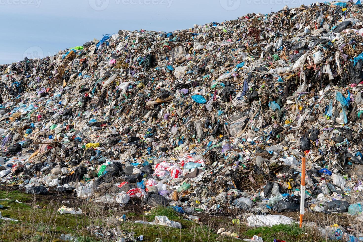 Extensive Landfill Area Filled with Mixed Waste Materials and Green Grass Environment photo