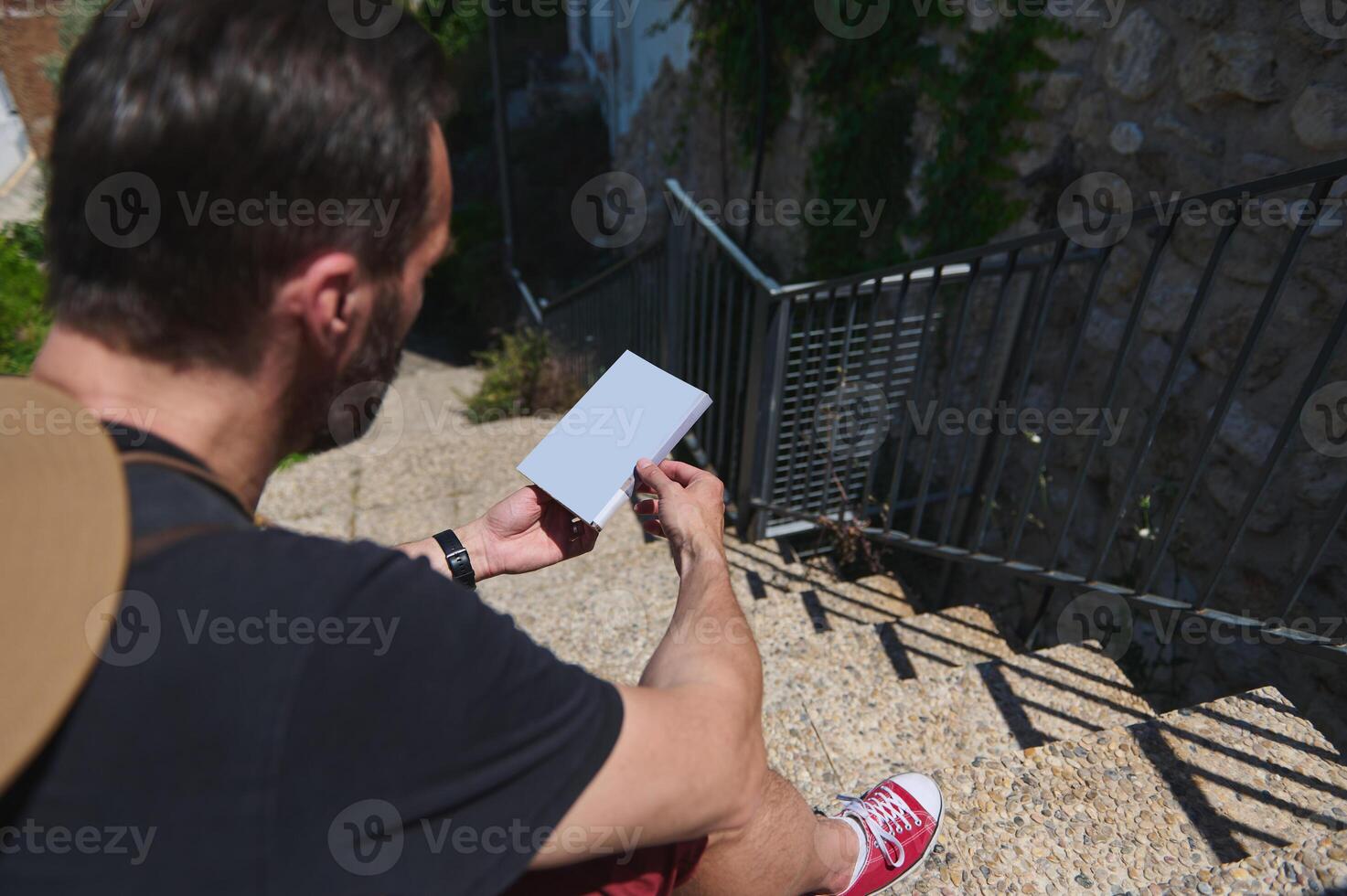 Traveler on Stone Stairs Observing a Map Amid Scenic Surroundings photo