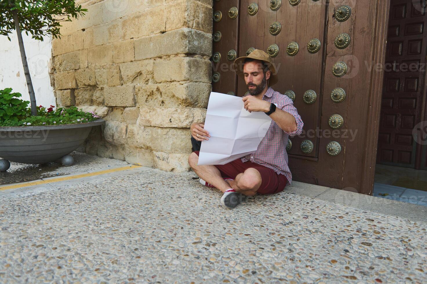 Traveler Exploring a Medieval City While Reading a Map Outdoors photo